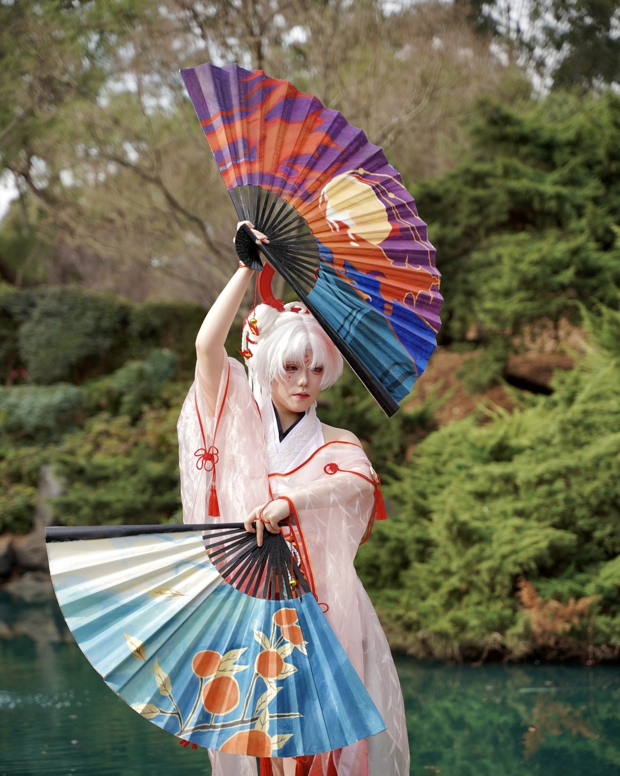 Portrait beside reflective pond with two fans