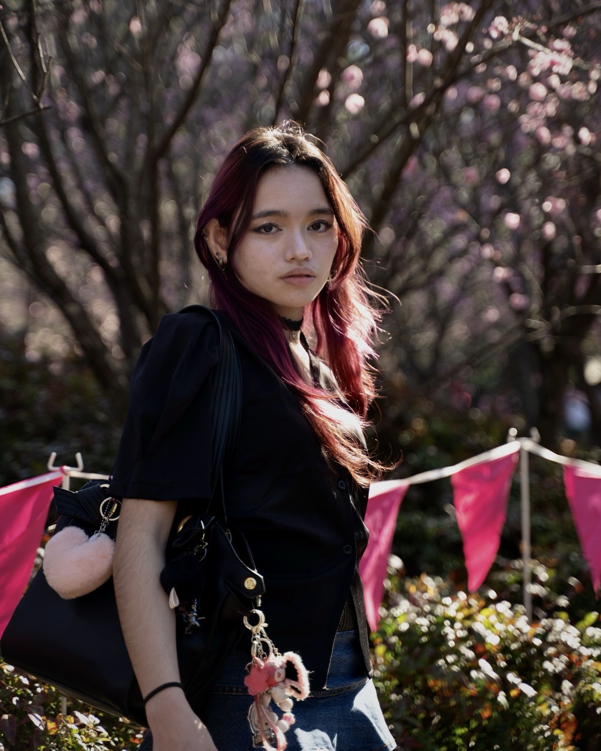 Backlit portrait among dark blossom branches